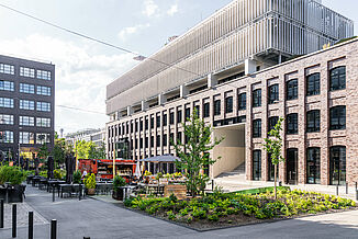 Inner courtyard with green spaces and seating areas from the Macherei in Munich.