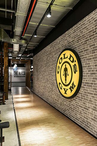 Interior view of the Gold's Gym fitness centre in Jena with large Gold's Gym logo on the wall.